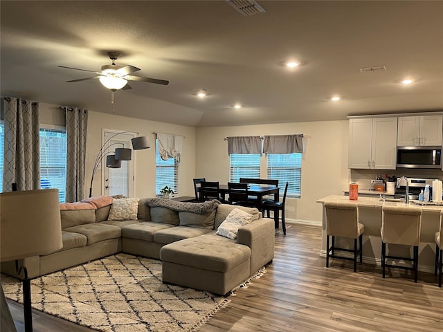 living area with recessed lighting, visible vents, light wood-style flooring, and ceiling fan