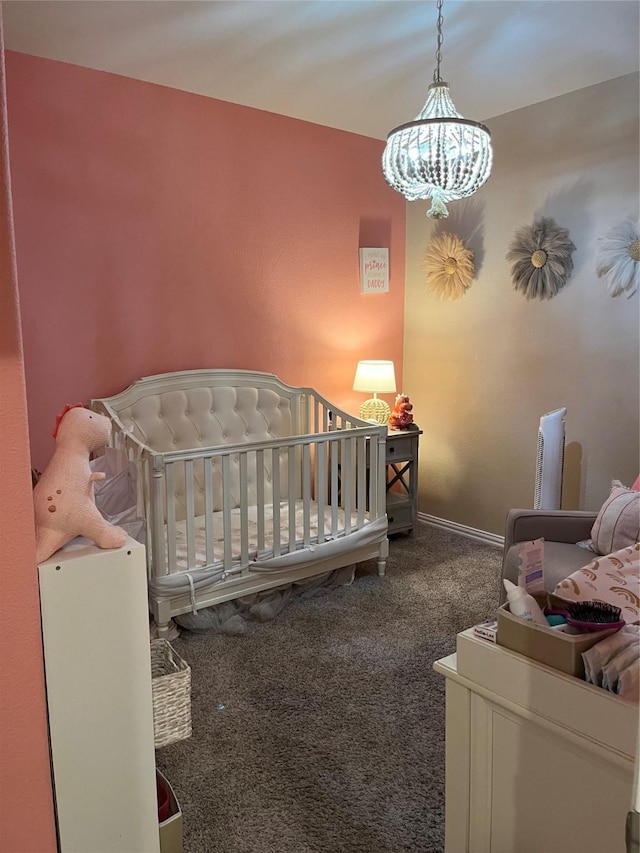 bedroom featuring baseboards, a crib, carpet, and an inviting chandelier