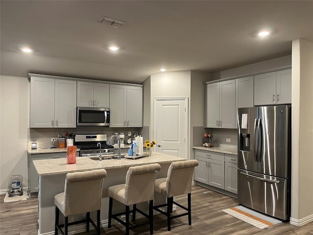 kitchen with visible vents, appliances with stainless steel finishes, dark wood-style flooring, gray cabinets, and a sink