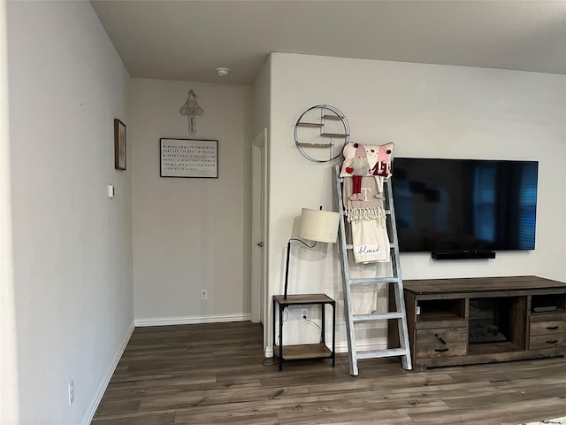 living area featuring baseboards and wood finished floors