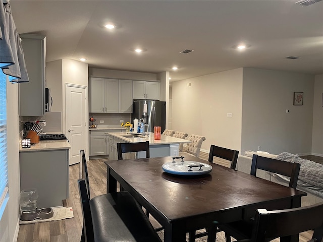 dining area featuring light wood-type flooring, baseboards, and recessed lighting