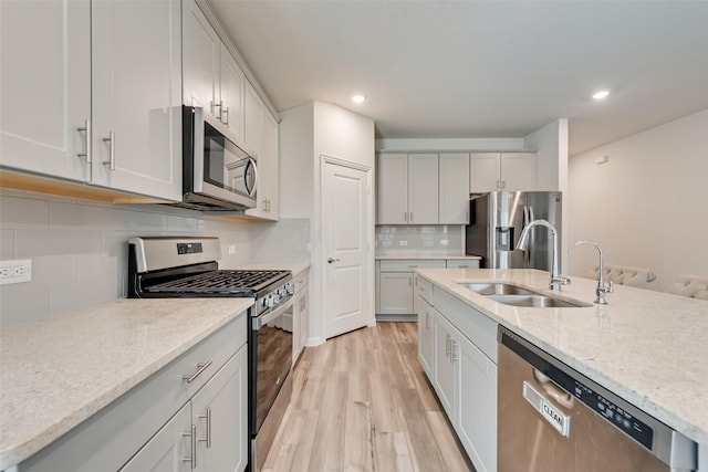 6116 Pathfinder Trl, Fort Worth, TX 76179 - kitchen with stainless steel appliances, a sink, light wood-style floors, recessed lighting, and backsplash