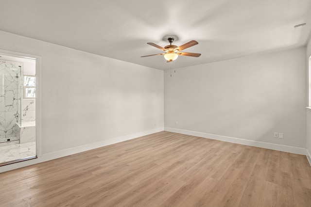 unfurnished room with baseboards, ceiling fan, and light wood-style floors