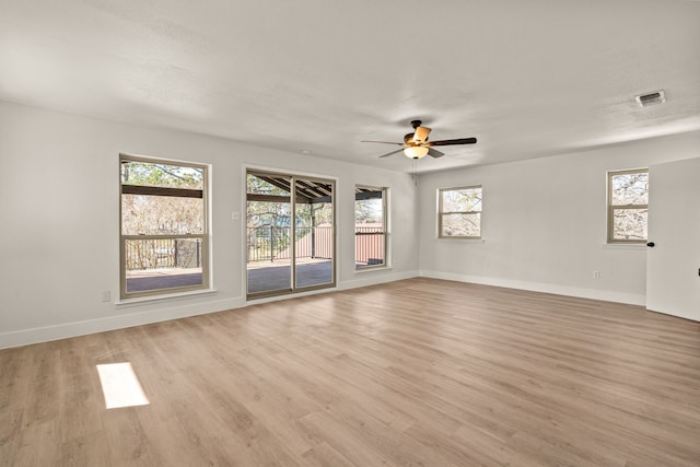 empty room featuring baseboards, ceiling fan, and light wood finished floors