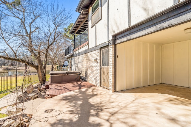 view of patio featuring fence and a hot tub