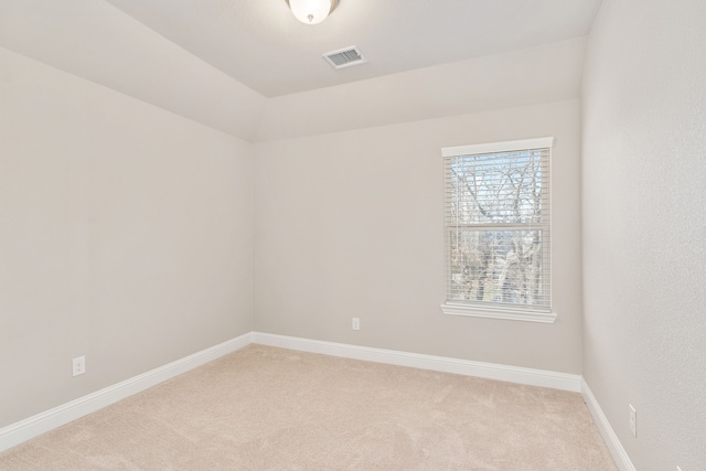 spare room with baseboards, visible vents, and light colored carpet