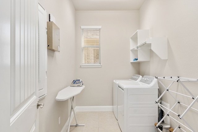 laundry room with laundry area, washer and clothes dryer, light tile patterned flooring, and baseboards