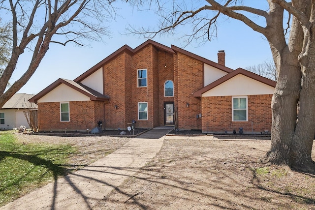 rear view of property with brick siding and a chimney