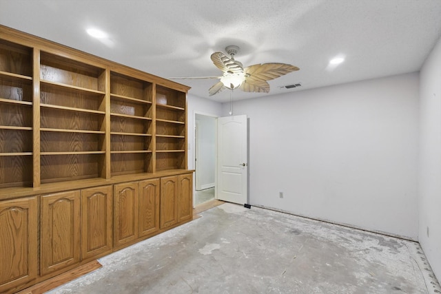 spare room with a ceiling fan and unfinished concrete flooring
