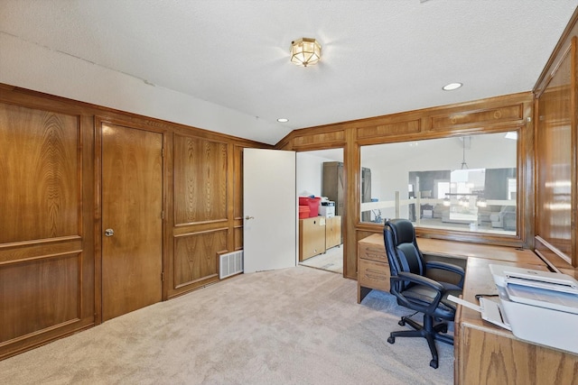 carpeted office with visible vents, a textured ceiling, and lofted ceiling