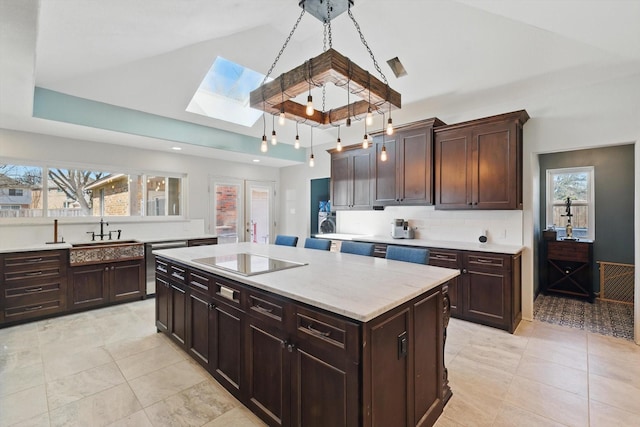 kitchen featuring black electric cooktop, a skylight, a sink, high vaulted ceiling, and light tile patterned floors
