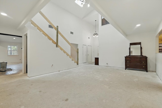 unfurnished living room with unfinished concrete floors, recessed lighting, and stairway