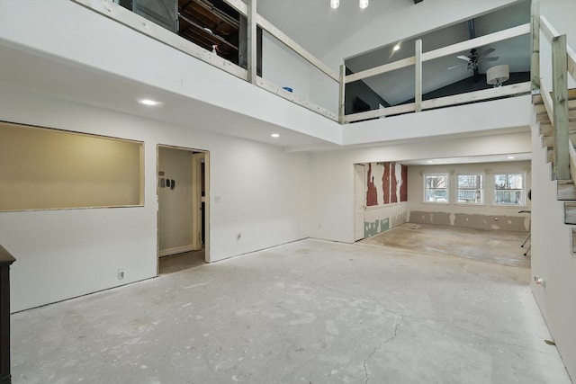 unfurnished room with ceiling fan and high vaulted ceiling