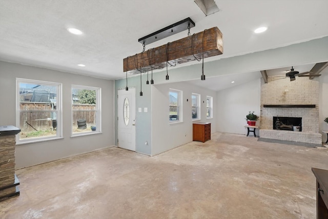 unfurnished living room featuring a fireplace, a ceiling fan, unfinished concrete floors, and lofted ceiling