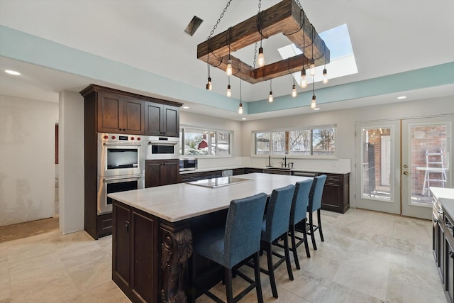 kitchen with stainless steel appliances, a sink, a center island, french doors, and healthy amount of natural light