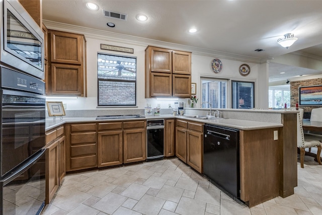 kitchen with a peninsula, visible vents, light countertops, ornamental molding, and black appliances