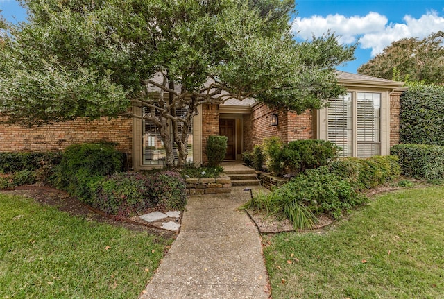 view of front of home with a front lawn and brick siding