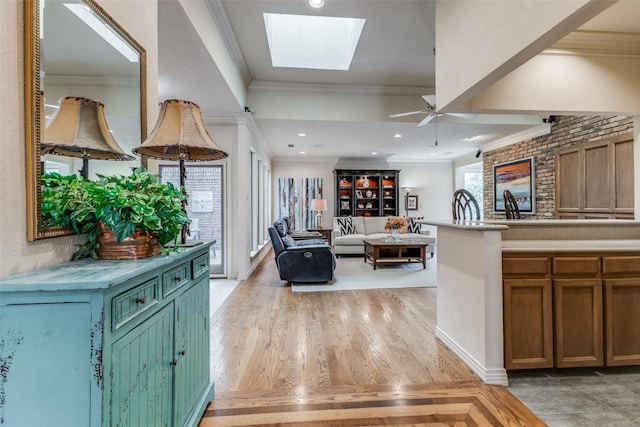 living room with a skylight, crown molding, light wood finished floors, and recessed lighting