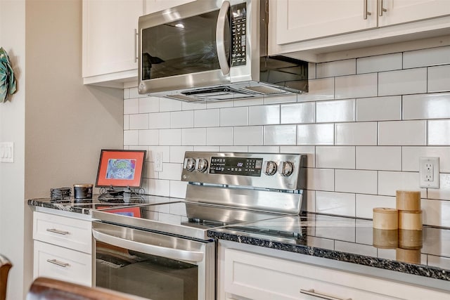 kitchen with appliances with stainless steel finishes, dark stone countertops, decorative backsplash, and white cabinetry