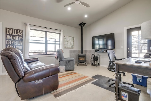 office area with finished concrete flooring, recessed lighting, a wood stove, vaulted ceiling, and ceiling fan