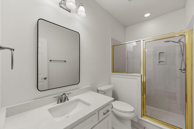 bathroom featuring a shower stall, toilet, and vanity