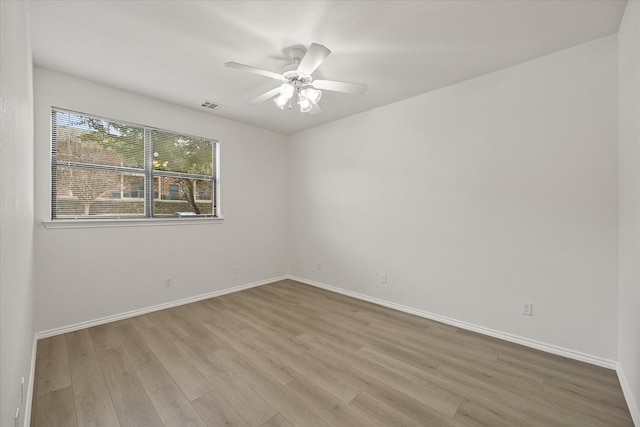 unfurnished room featuring ceiling fan, wood finished floors, visible vents, and baseboards