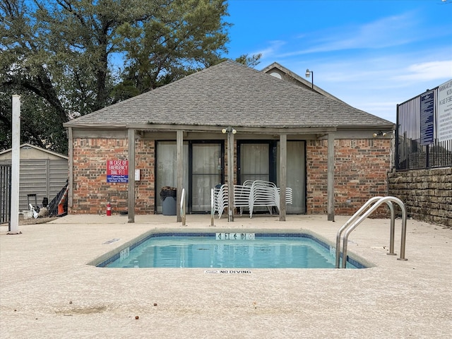 community pool featuring a patio area, a shed, and an outdoor structure