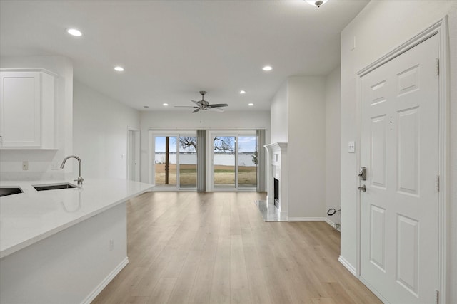 interior space featuring ceiling fan, a fireplace, light wood-style flooring, and recessed lighting