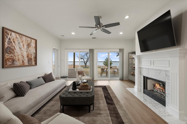 living room featuring a fireplace, recessed lighting, visible vents, ceiling fan, and wood finished floors