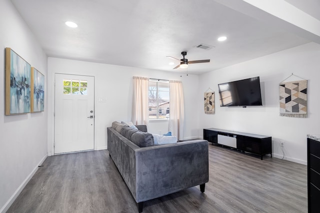 living area with plenty of natural light, wood finished floors, visible vents, and baseboards