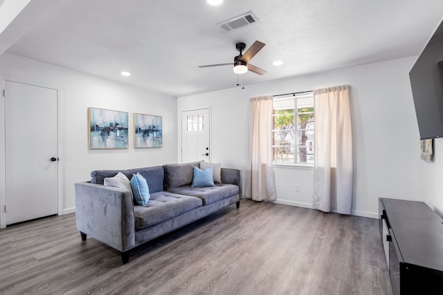 living area with baseboards, visible vents, wood finished floors, and recessed lighting