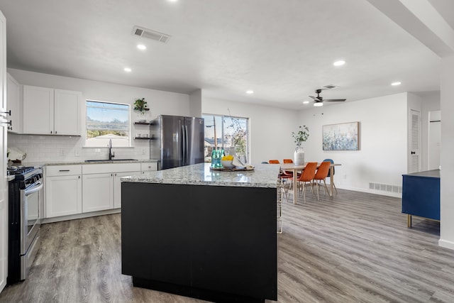 kitchen featuring appliances with stainless steel finishes, a wealth of natural light, visible vents, and a sink