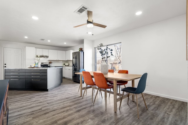 dining room featuring baseboards, visible vents, wood finished floors, and recessed lighting