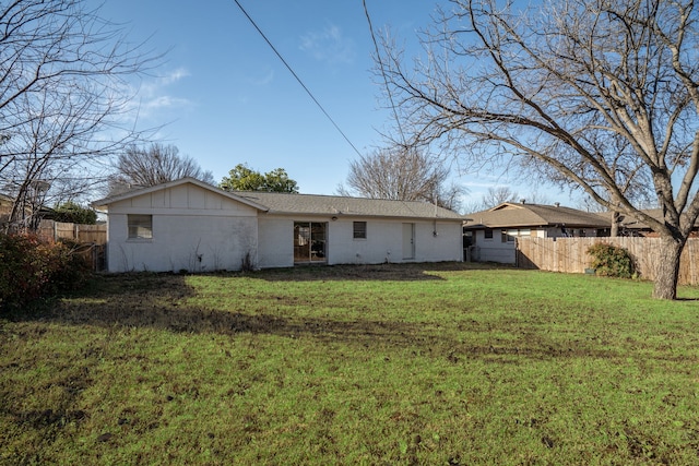 back of property with fence and a yard