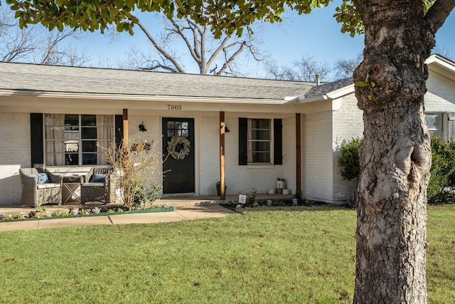 view of front of house with a porch, an outdoor hangout area, brick siding, a shingled roof, and a front yard