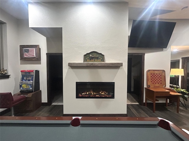 interior details with wood finished floors and a glass covered fireplace