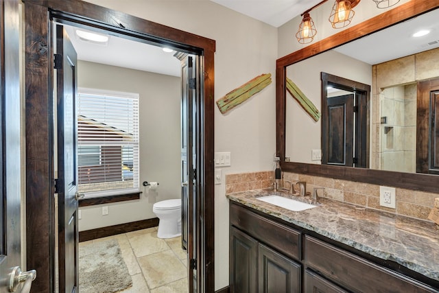 bathroom with toilet, visible vents, vanity, and baseboards