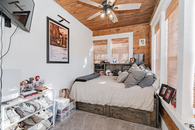 carpeted bedroom with wood walls and wooden ceiling