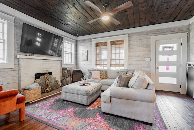 living area with wooden walls, wood ceiling, a fireplace, and wood-type flooring