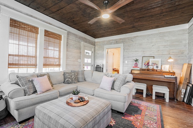 living area featuring wood ceiling, ceiling fan, wooden walls, and wood finished floors