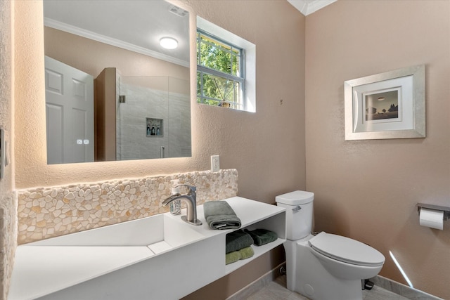 full bath featuring toilet, a stall shower, baseboards, a textured wall, and ornamental molding
