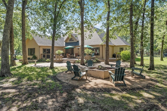 back of property featuring a patio and a shingled roof