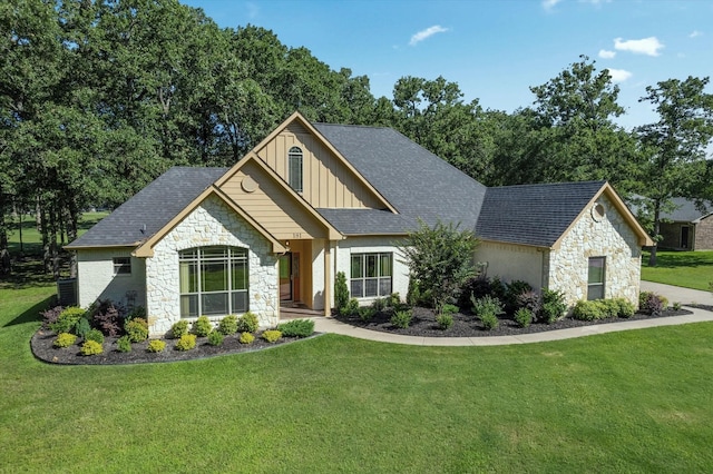 view of front of house with stone siding, a front lawn, roof with shingles, and board and batten siding