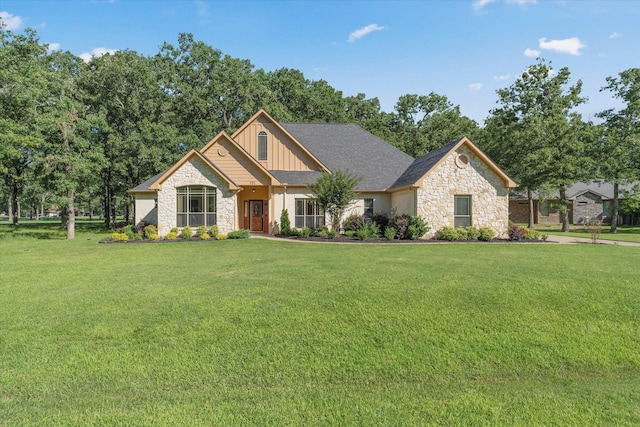 view of front of property with board and batten siding, stone siding, and a front yard