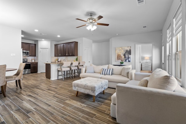 living area with dark wood-style floors, recessed lighting, visible vents, and ceiling fan