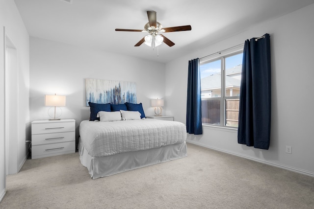 bedroom featuring baseboards, ceiling fan, and light colored carpet