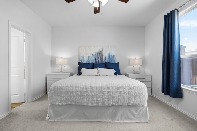 carpeted bedroom with a ceiling fan and baseboards