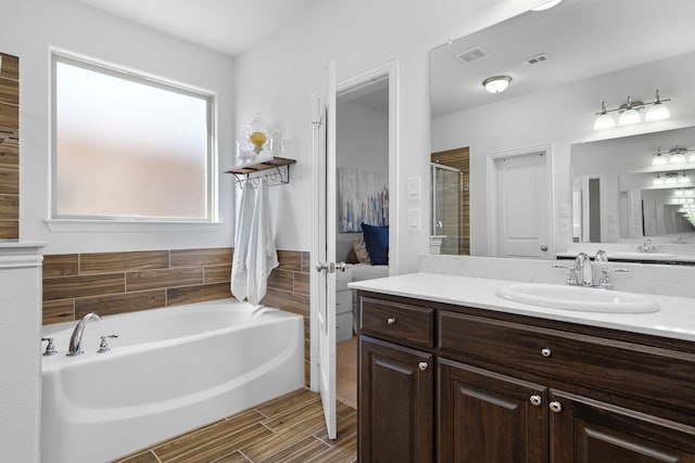 full bathroom featuring visible vents, a garden tub, a shower stall, and vanity