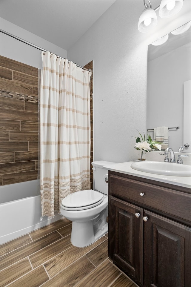 bathroom with wood tiled floor, vanity, toilet, and shower / bath combo with shower curtain