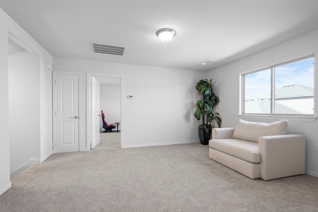 living area featuring carpet floors, baseboards, and visible vents